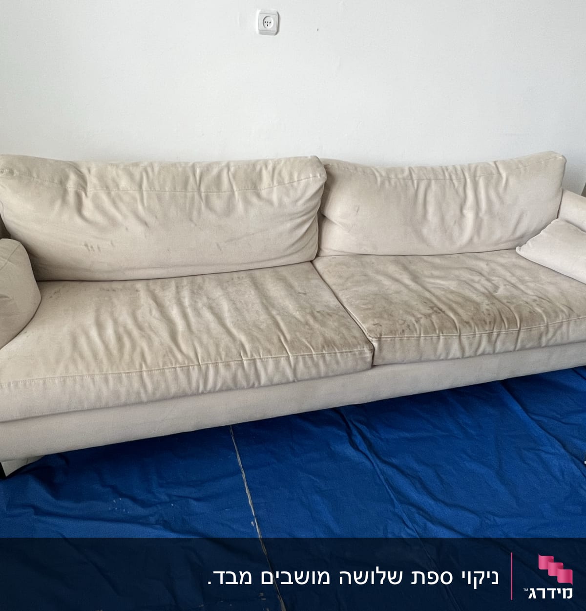 ספה בהירה עם כתמים על יריעת בד כחולה